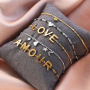 Et voici comment combiner les &eacute;l&eacute;ments de notre collection L-O-V-E et nos boucles d&rsquo;oreilles en acier inoxydable :